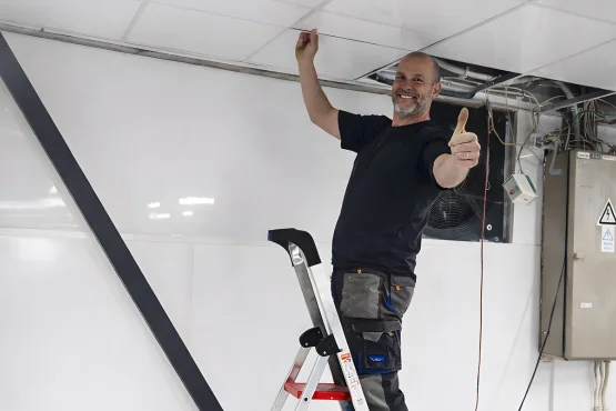 artisan pose plaque de pvc au plafond et sur les murs